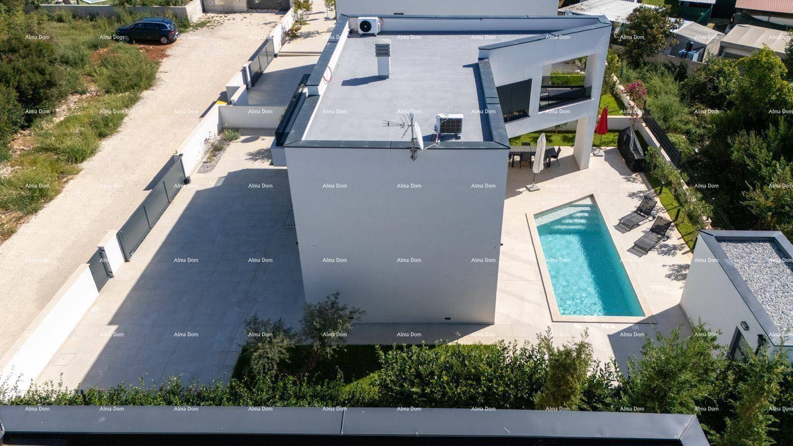 Seitenansicht einer modernen Villa mit Flachdach, privatem Pool und gepflastertem Außenbereich.