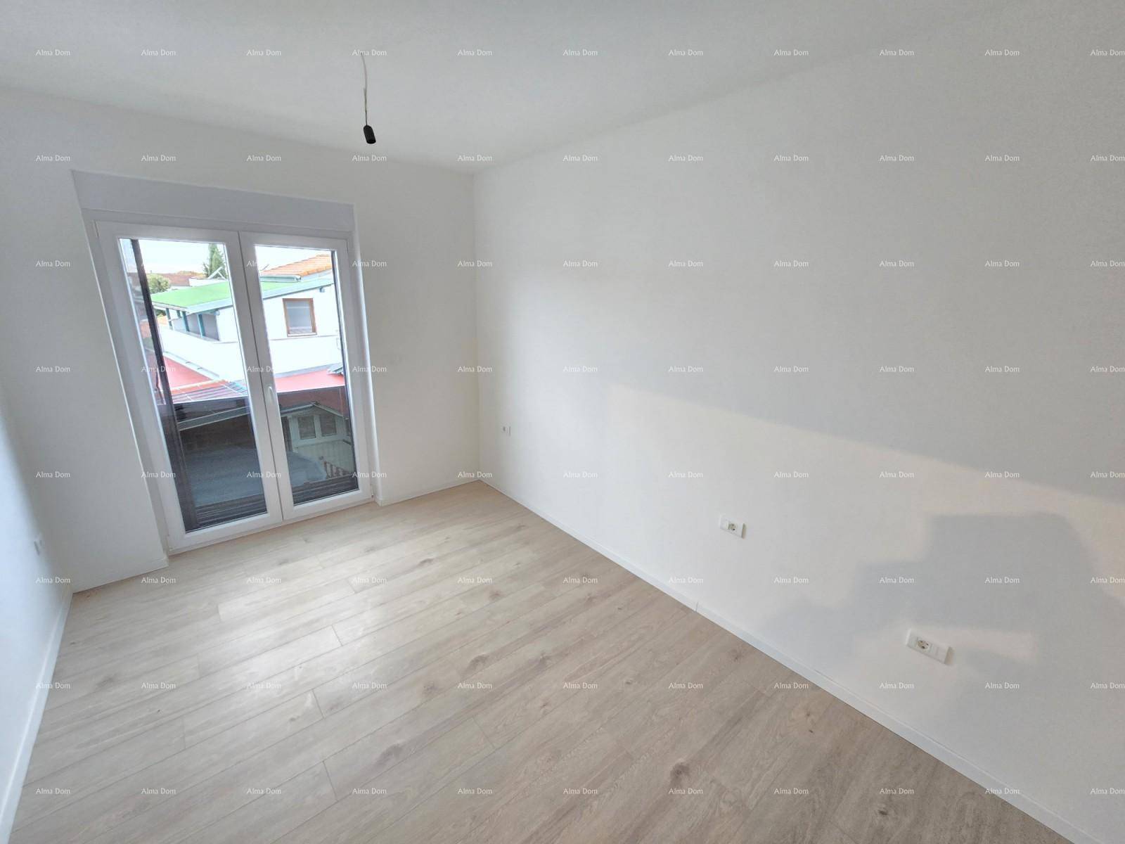 Heller Raum mit hellem Laminatboden und großen Fenstern, die viel Tageslicht hereinlassen.