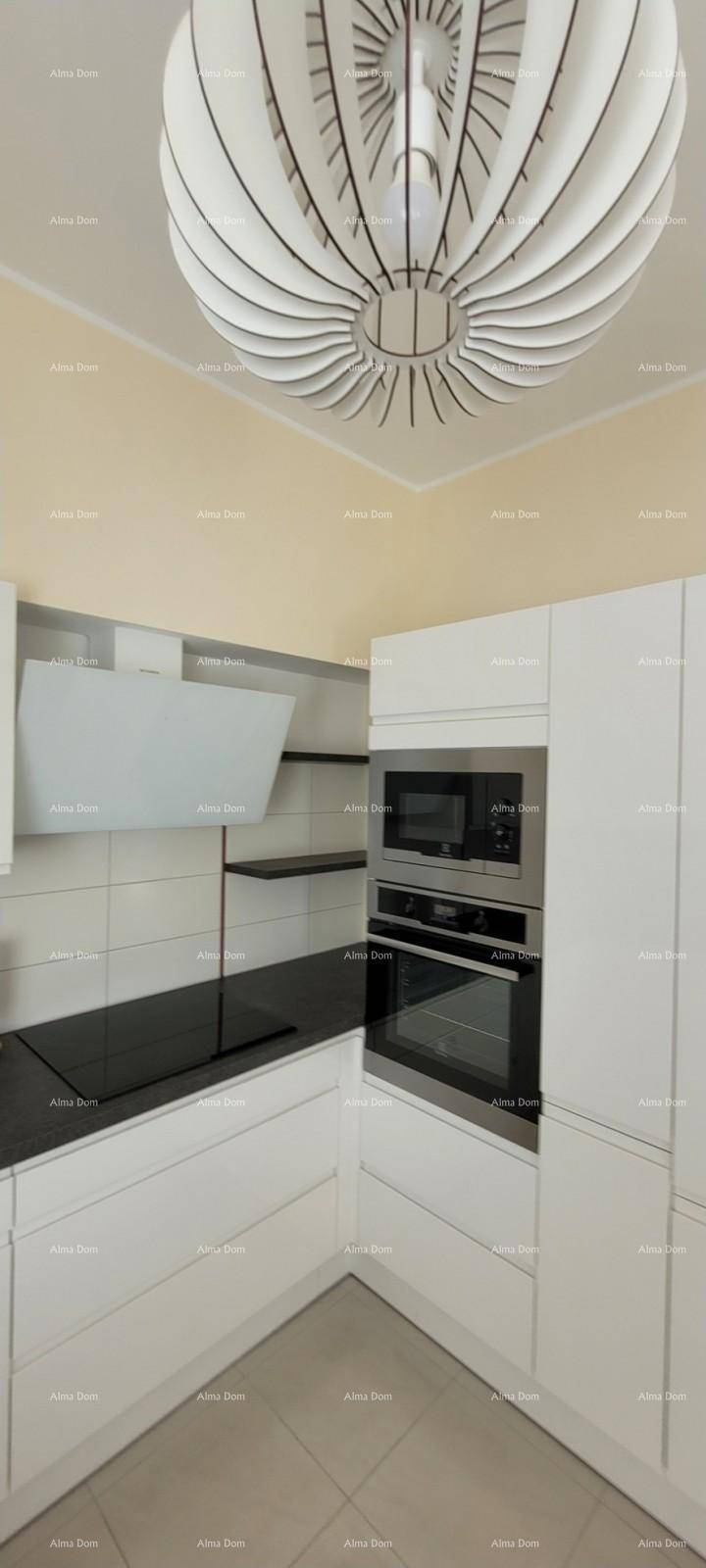 Moderne Küche mit Induktionskochfeld, integriertem Backofen und Mikrowelle unter einer stilvollen Deckenleuchte.