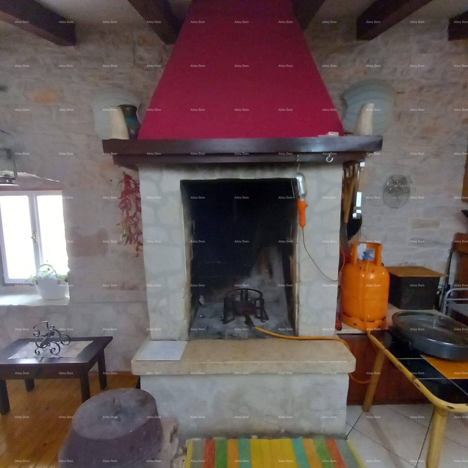 Rustikaler Wohnbereich mit großem Steinkamin, Holzbalken an der Decke und traditioneller Einrichtung.