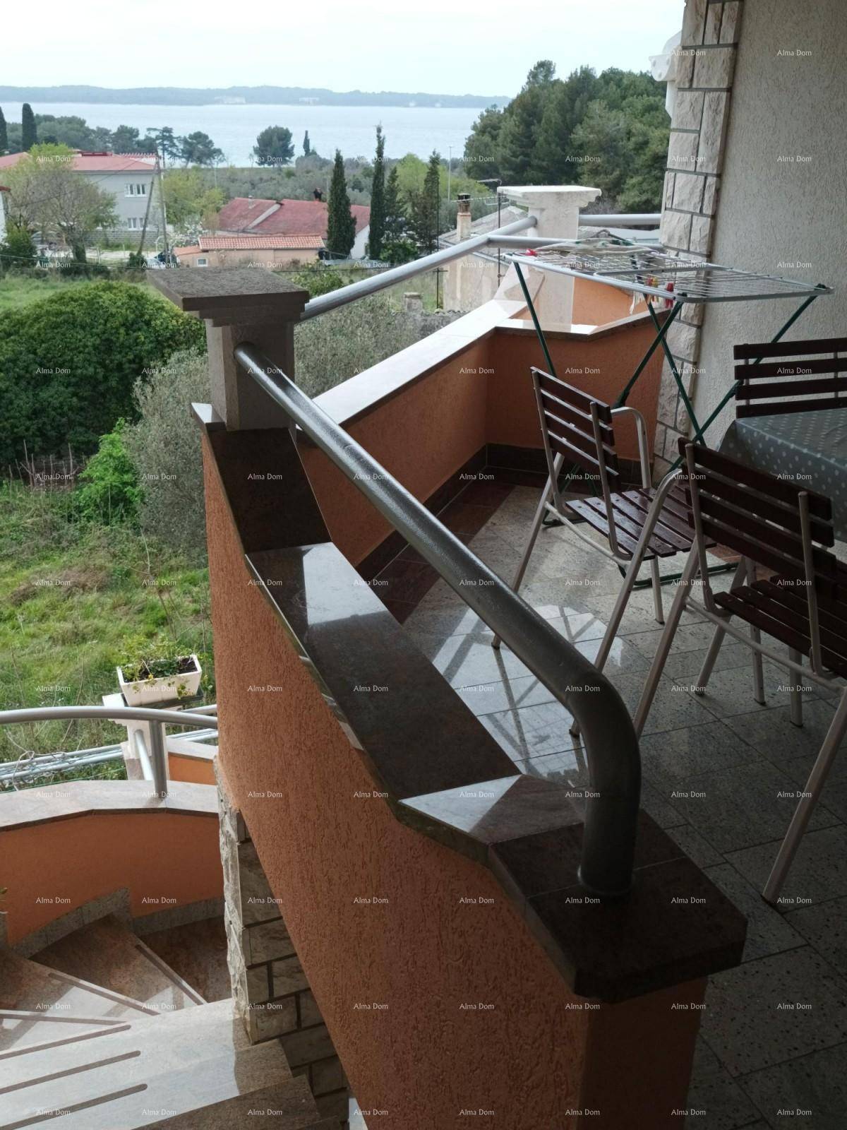 Balkon mit Metallgeländer, Sitzgelegenheiten und einem Wäscheständer mit Meerblick.