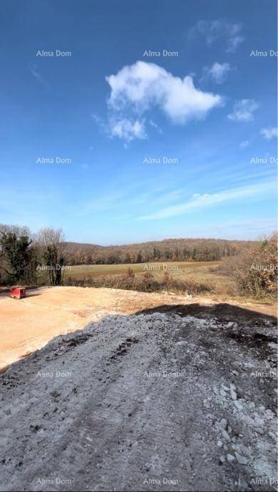 Offenes Gelände mit Erdhügeln und weitem Blick über Felder und Wälder unter blauem Himmel.