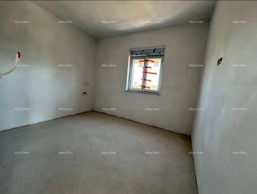 Geräumiges, unfertiges Schlafzimmer mit einem Fenster und vorbereiteten Installationen für die Endausstattung.