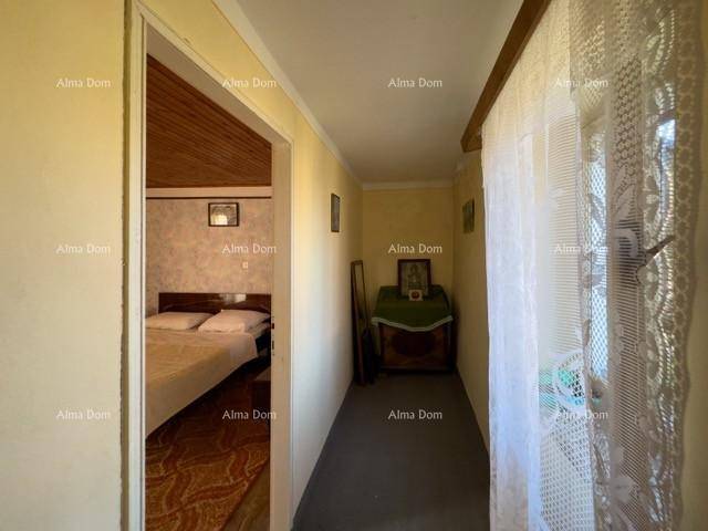 Schmaler Flur mit Blick in ein weiteres Schlafzimmer und einem Fenster mit Spitzenvorhang.