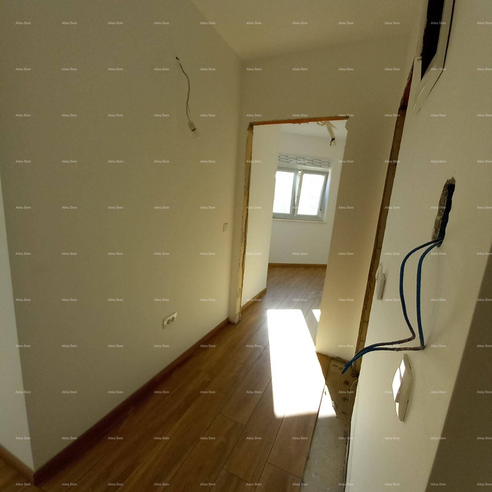 Heller Flur mit neuem Laminatboden, der zu verschiedenen Zimmern und einem Fenster führt.