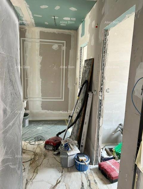 Flur im Bau mit marmoriertem Fliesenboden und unfertigen Wänden, bereit für den Ausbau.