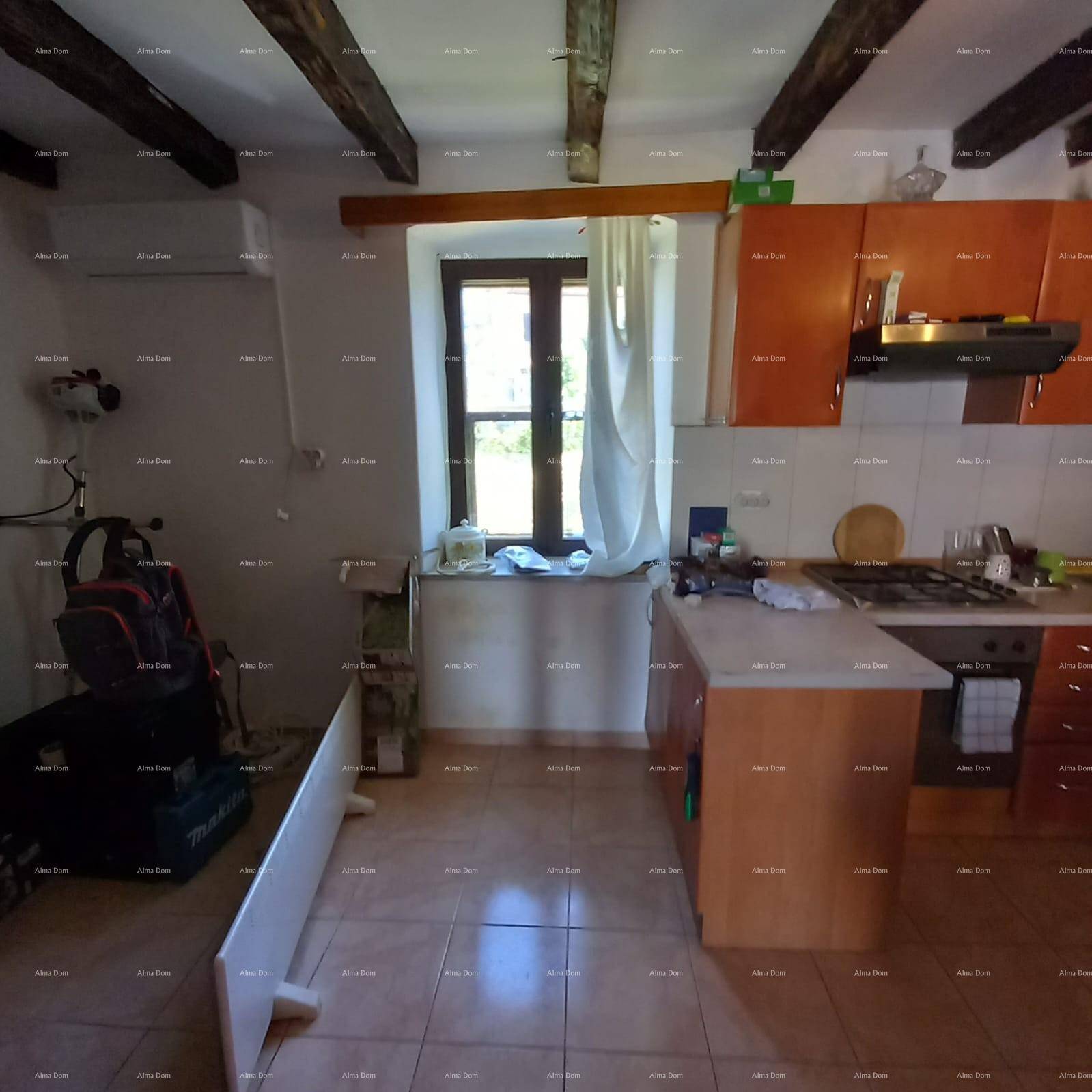 Funktionale Küche mit Holzschränken, Gasherd und einem Fenster mit Blick ins Grüne.
