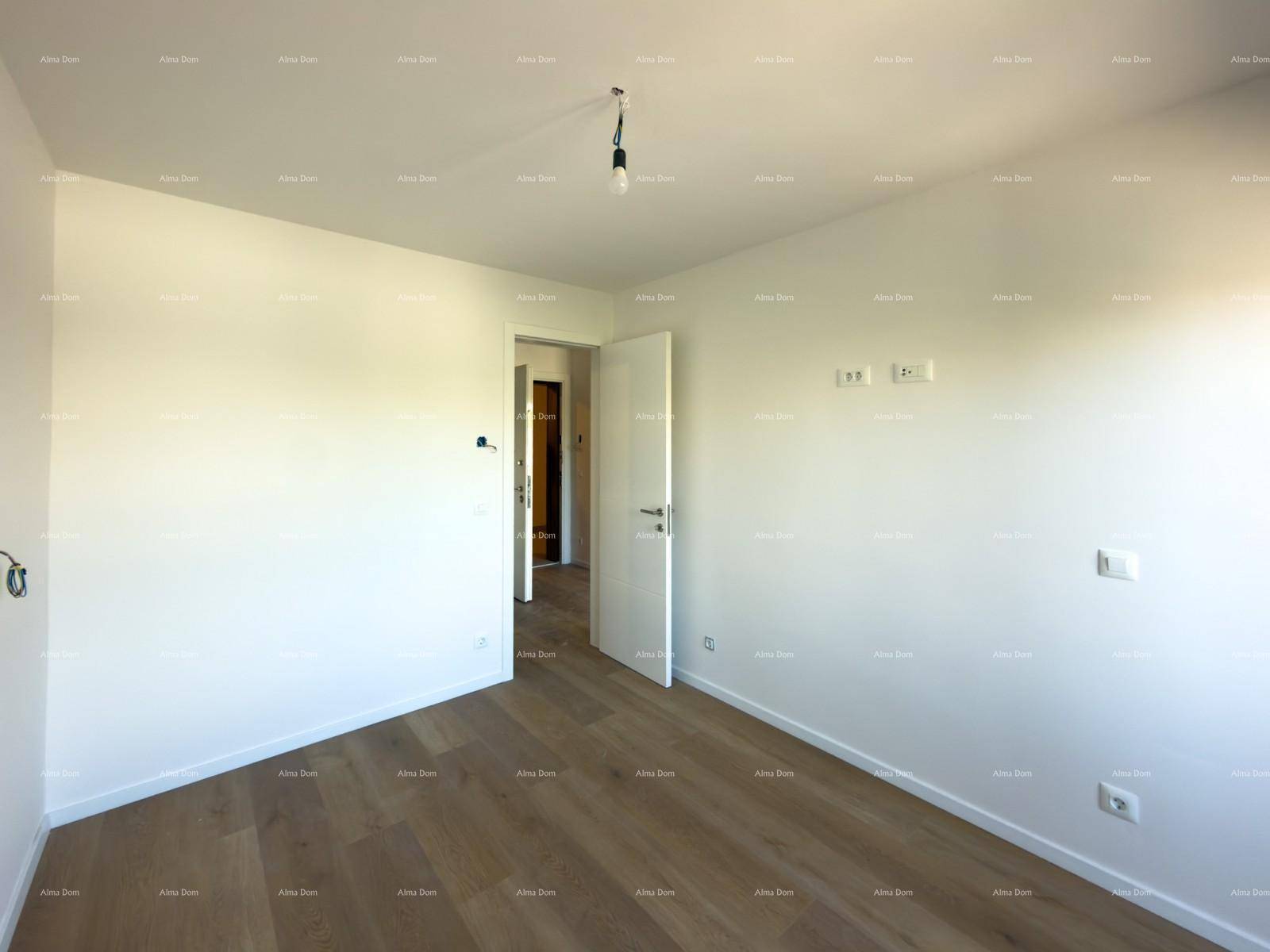 Leeres Schlafzimmer mit Holzboden und Türzugang, bereit für die Einrichtung.