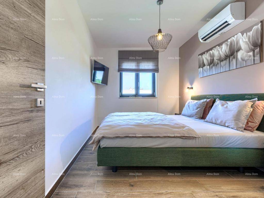 Schlafzimmer mit Klimaanlage, Holzboden und einem Fenster für natürliches Licht.