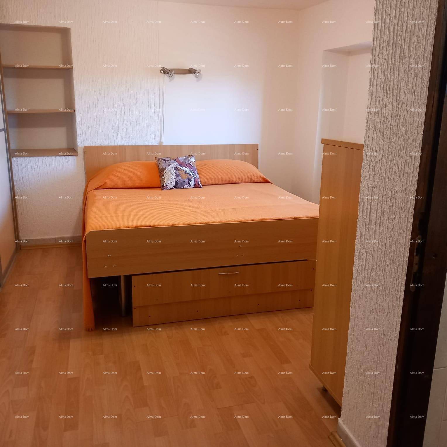 Schlafzimmer mit Holzbett, integriertem Stauraum und Laminatboden.