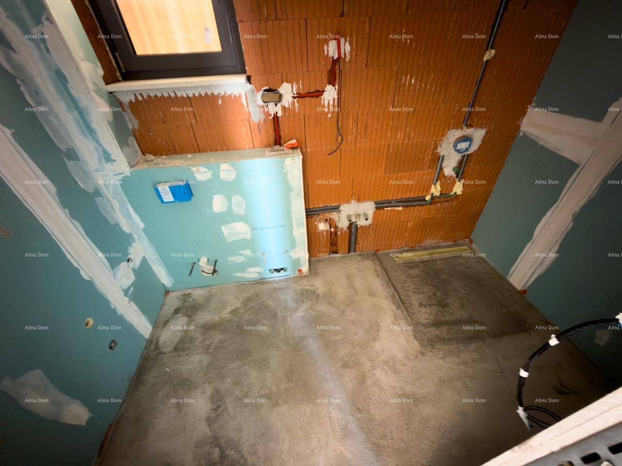 Blick von oben in ein unfertiges Badezimmer mit Betonboden, Ziegelwänden und Sanitärinstallationen.