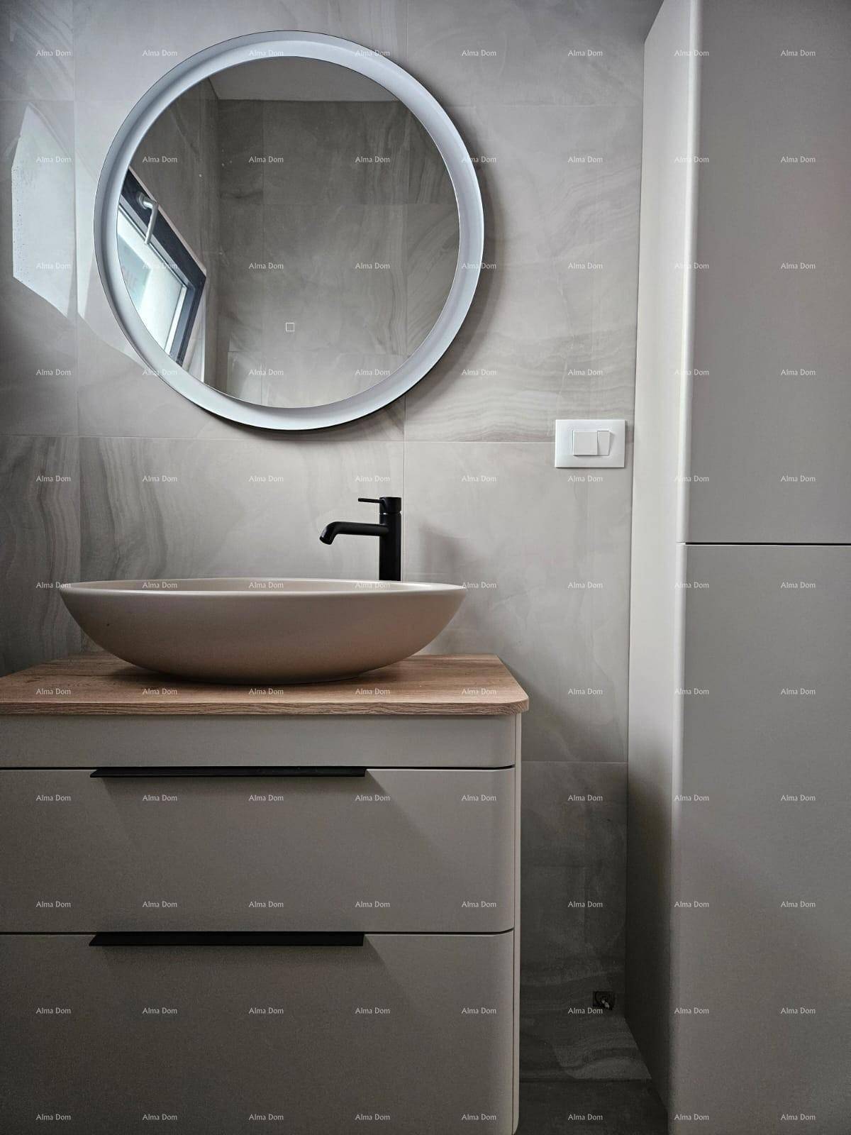 Modernes Badezimmer mit rundem beleuchtetem Spiegel, Aufsatzwaschbecken und Holzwaschtisch.