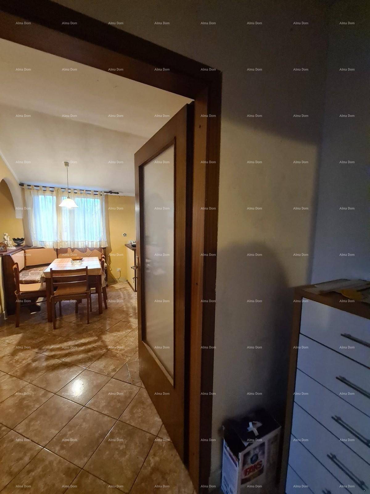 Blick durch eine Holztür in einen Essbereich mit Tisch und Sitzgelegenheiten.