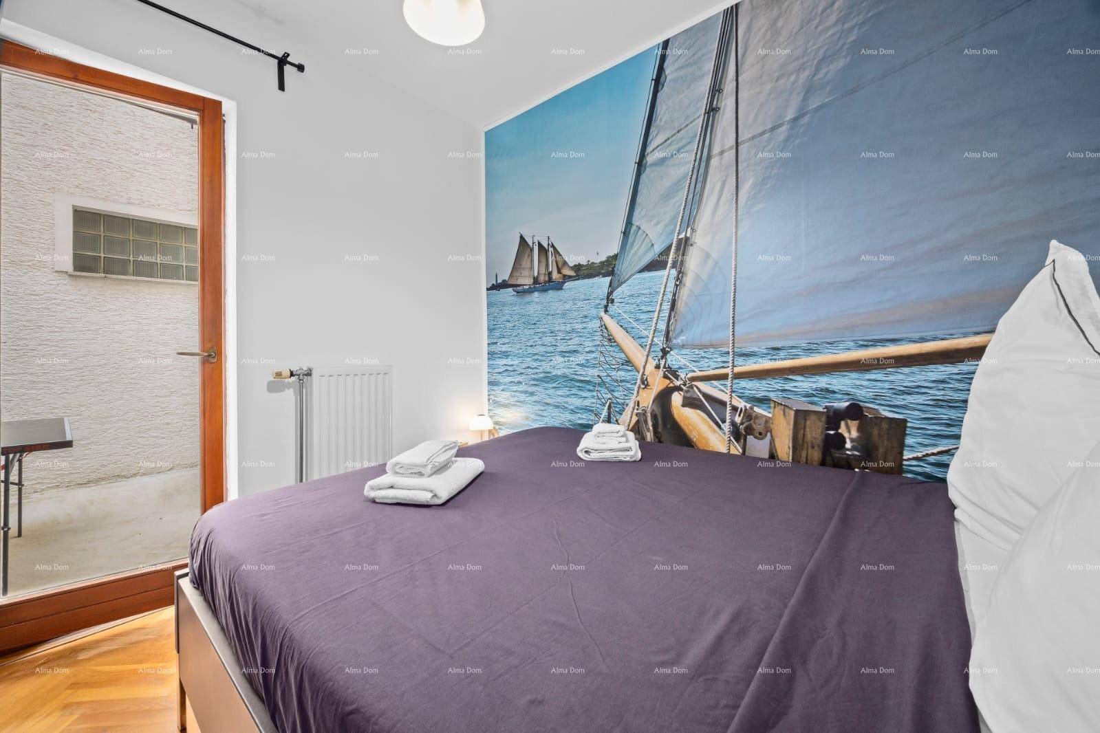 Schlafzimmer mit großem Wandbild, Doppelbett und Holzboden, bietet direkten Zugang nach draußen.