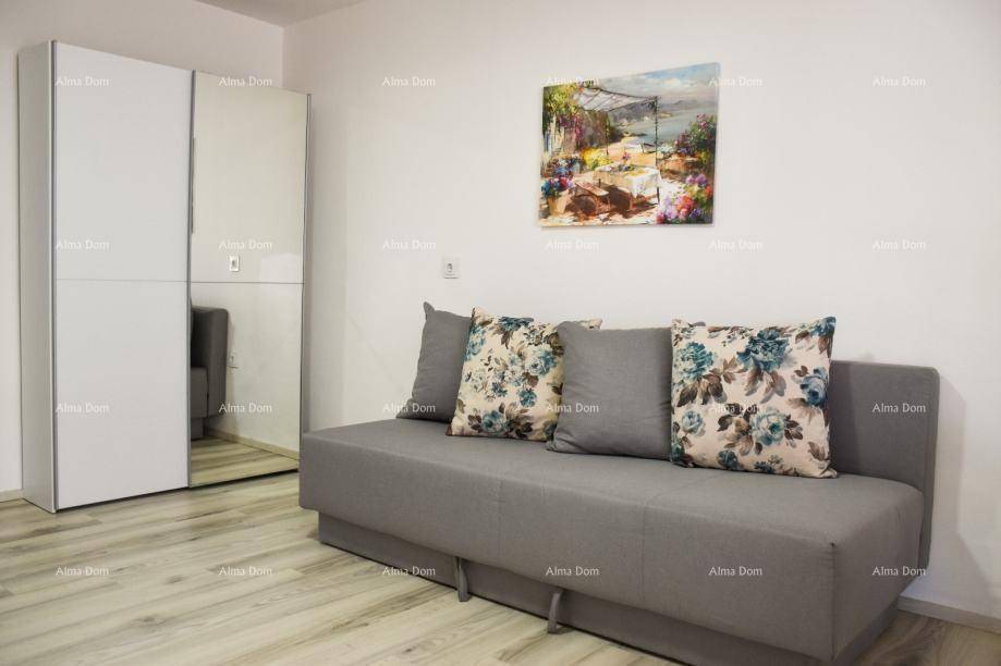 Schlafsofa mit floralen Kissen und einem Kleiderschrank mit Spiegeltür im Wohnbereich.