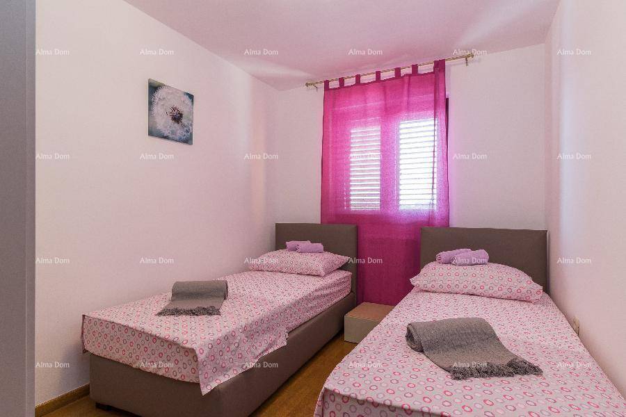 Freundliches Schlafzimmer mit zwei Einzelbetten, pinker Bettwäsche und passenden Vorhängen.