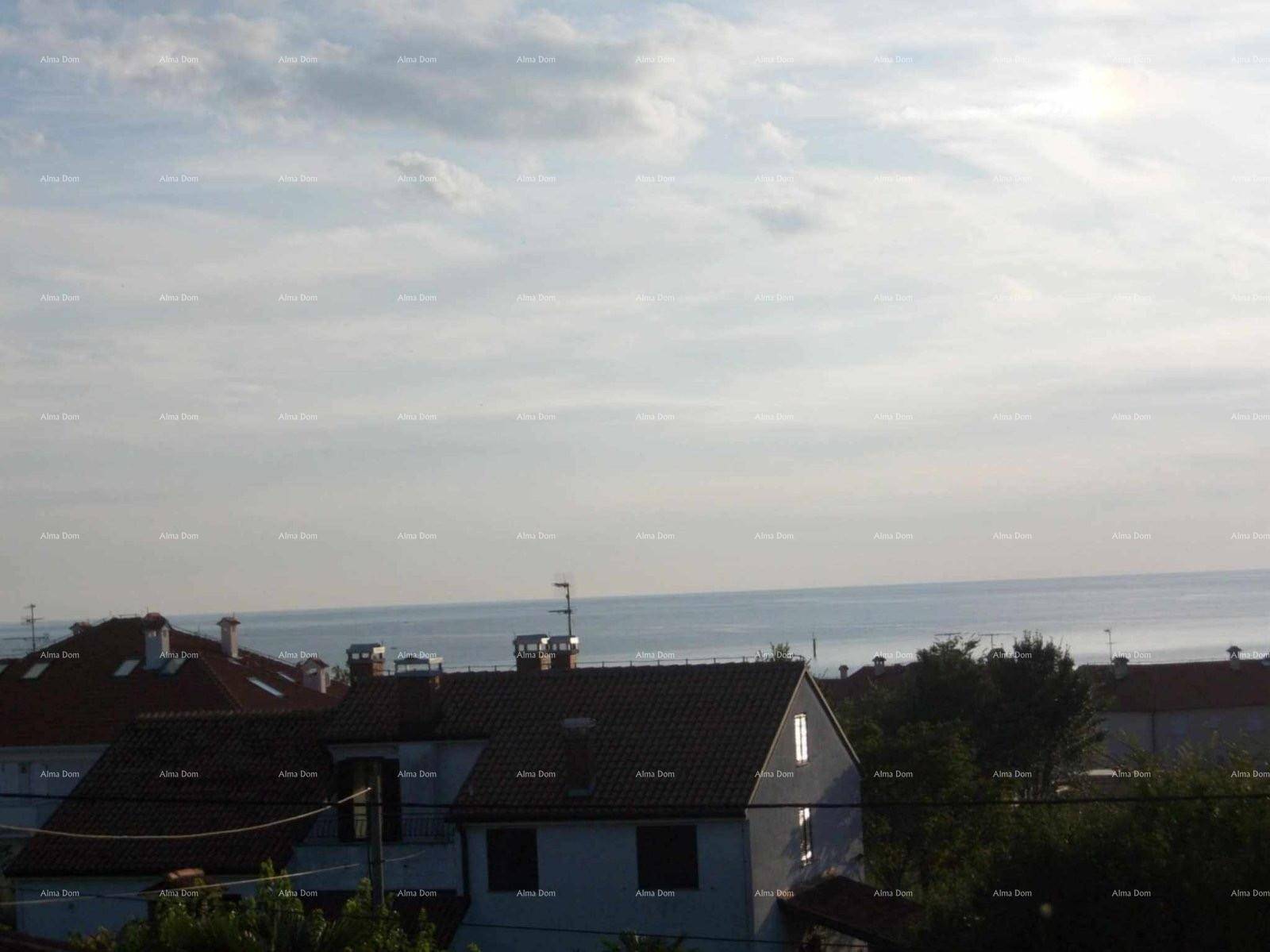 Weitblick über die Dächer der Häuser bis zum Meer unter einem bewölkten Himmel.