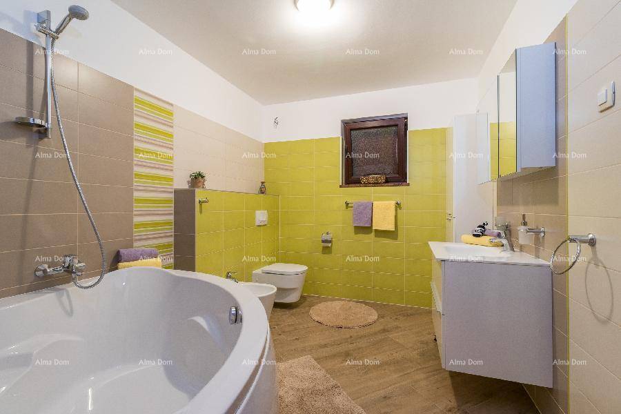 Geräumiges Badezimmer mit Eckbadewanne, WC, Bidet, Waschbecken und Fenster.