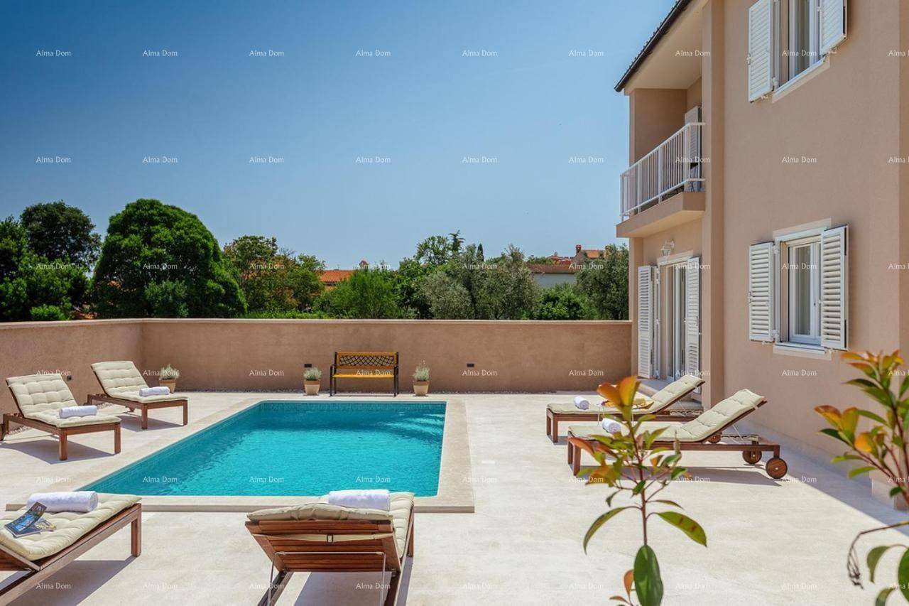 Entspannender Poolbereich mit Sonnenliegen und Blick auf die umliegende grüne Landschaft.