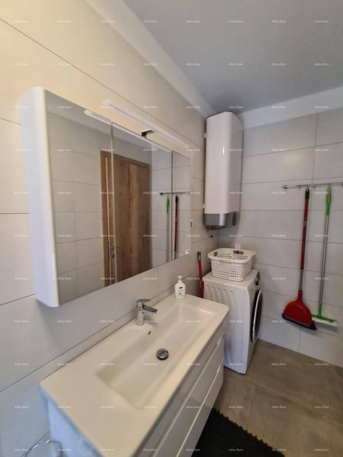 Badezimmer mit Waschbecken, Spiegelschrank und integrierter Waschmaschine.