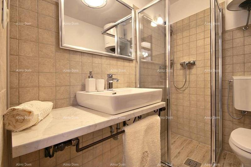 Modernes Badezimmer mit begehbarer Dusche, Einzelwaschbecken und hellen Fliesen.