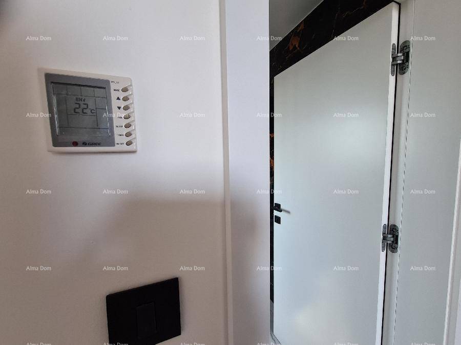 Wandthermostat zur Klimasteuerung neben einer Tür in einem modernen Innenraum.