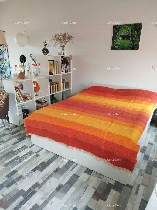 Schlafzimmer mit einem Bett, Bücherregal und einem Bodenbelag aus gemusterten Fliesen.