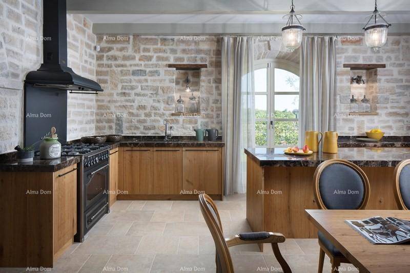Rustikale Küche mit Holzelementen, Steinwänden und einem großen Gasherd, ideal für Kochliebhaber.