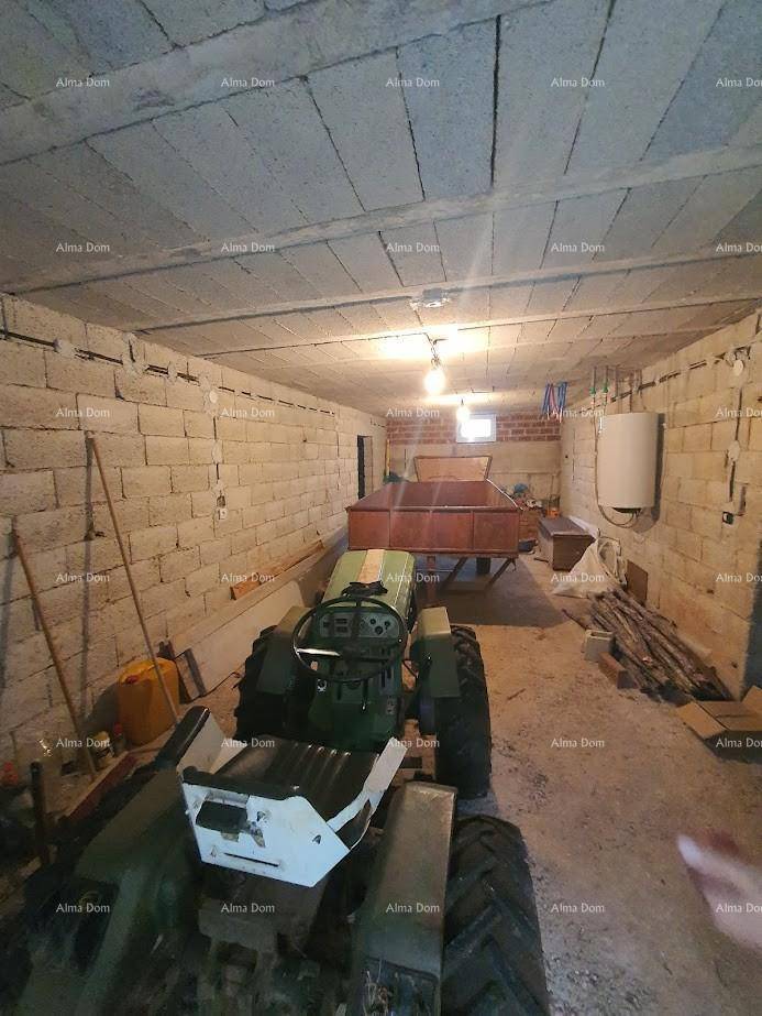 Geräumige Garage oder Werkstatt mit Betonwänden und einem Traktor.