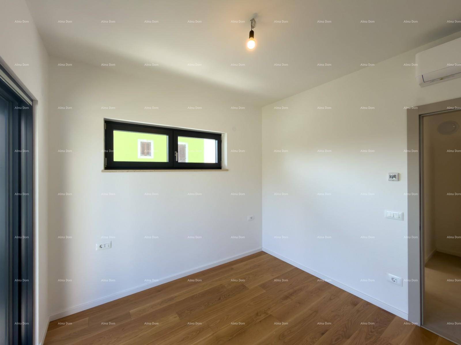 Leeres Schlafzimmer mit Holzboden, Klimaanlage und einem Fenster mit Blick ins Grüne.