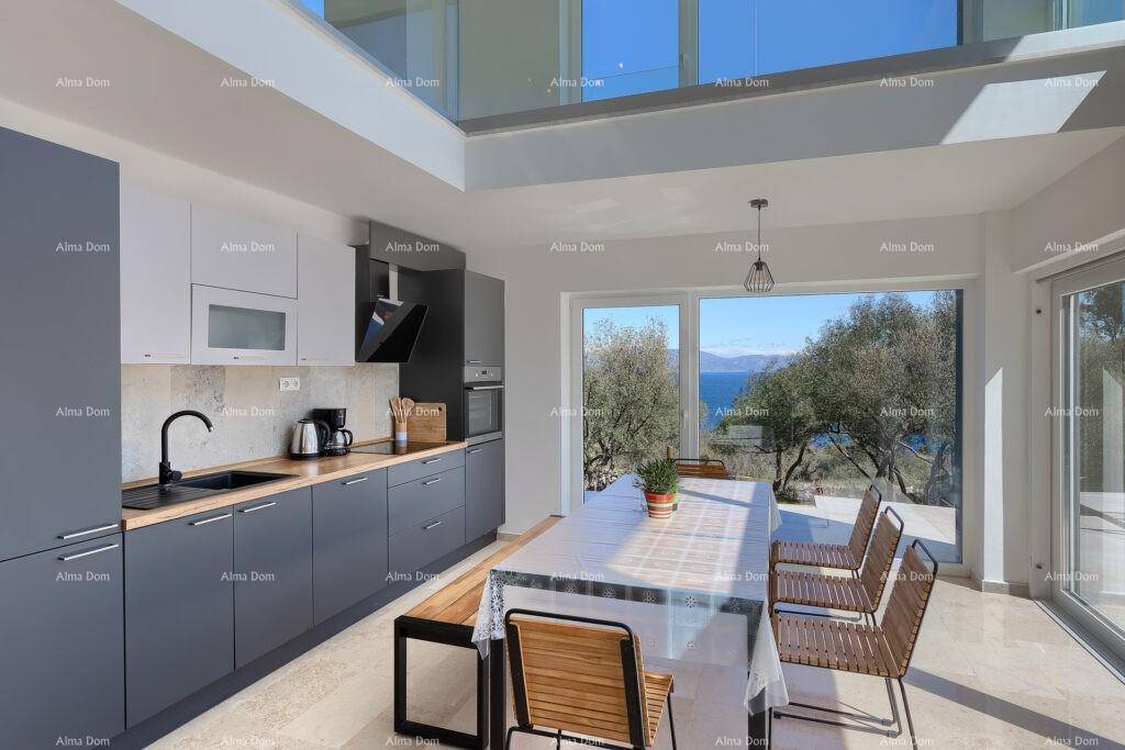 Moderne Küche mit grauen Schränken, Essbereich und großen Fenstern mit Meerblick.