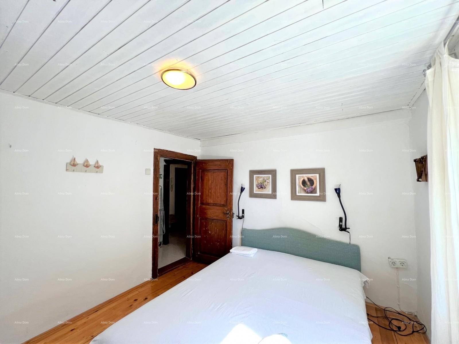 Schlafzimmer mit Holzdielenboden, weißer Holzdecke und einem Doppelbett.