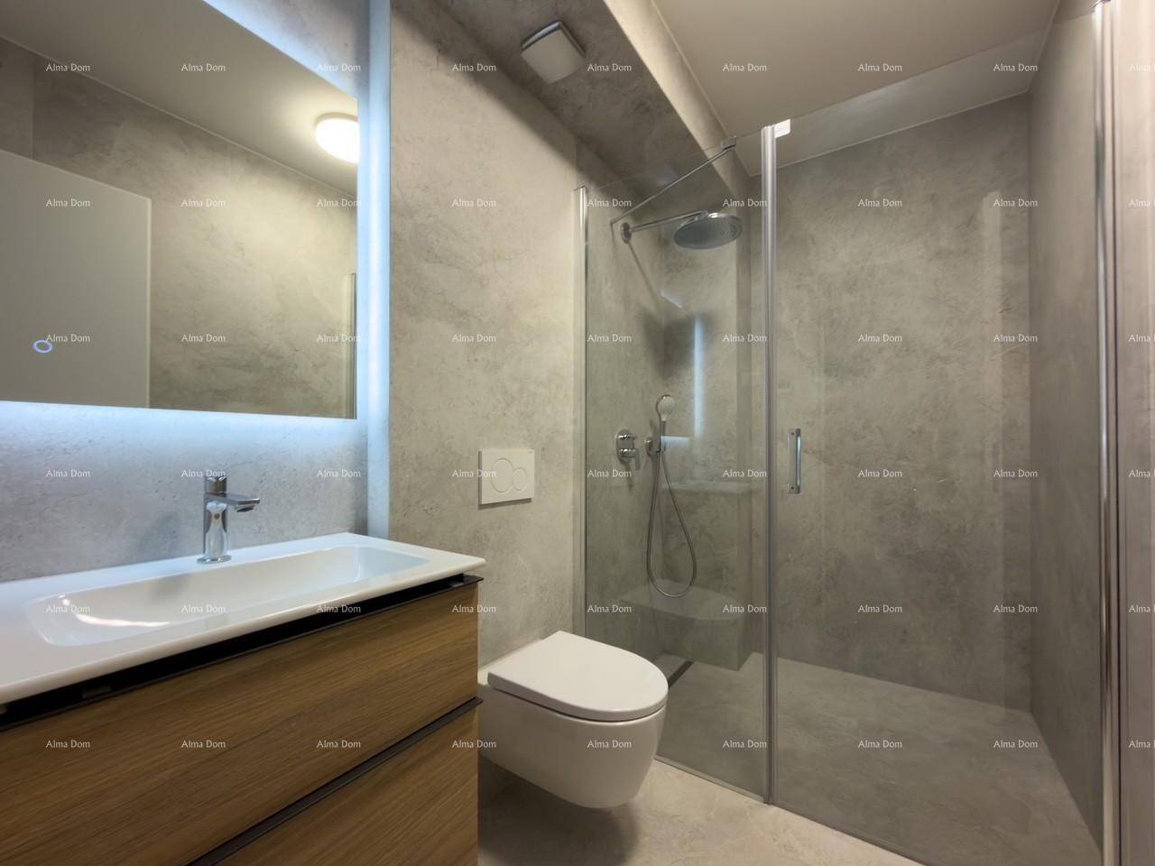 Modernes Badezimmer mit begehbarer Dusche, Wand-WC und beleuchtetem Spiegel über dem Waschtisch.