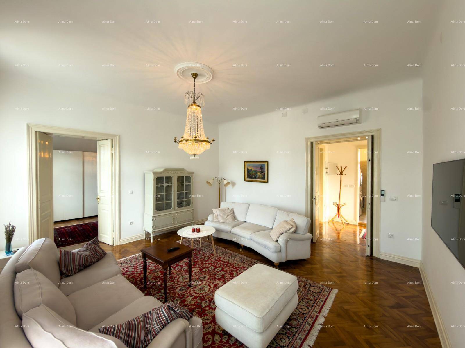 Helles Wohnzimmer mit elegantem Kronleuchter, bequemen Sofas und klassischem Fischgrätparkettboden.