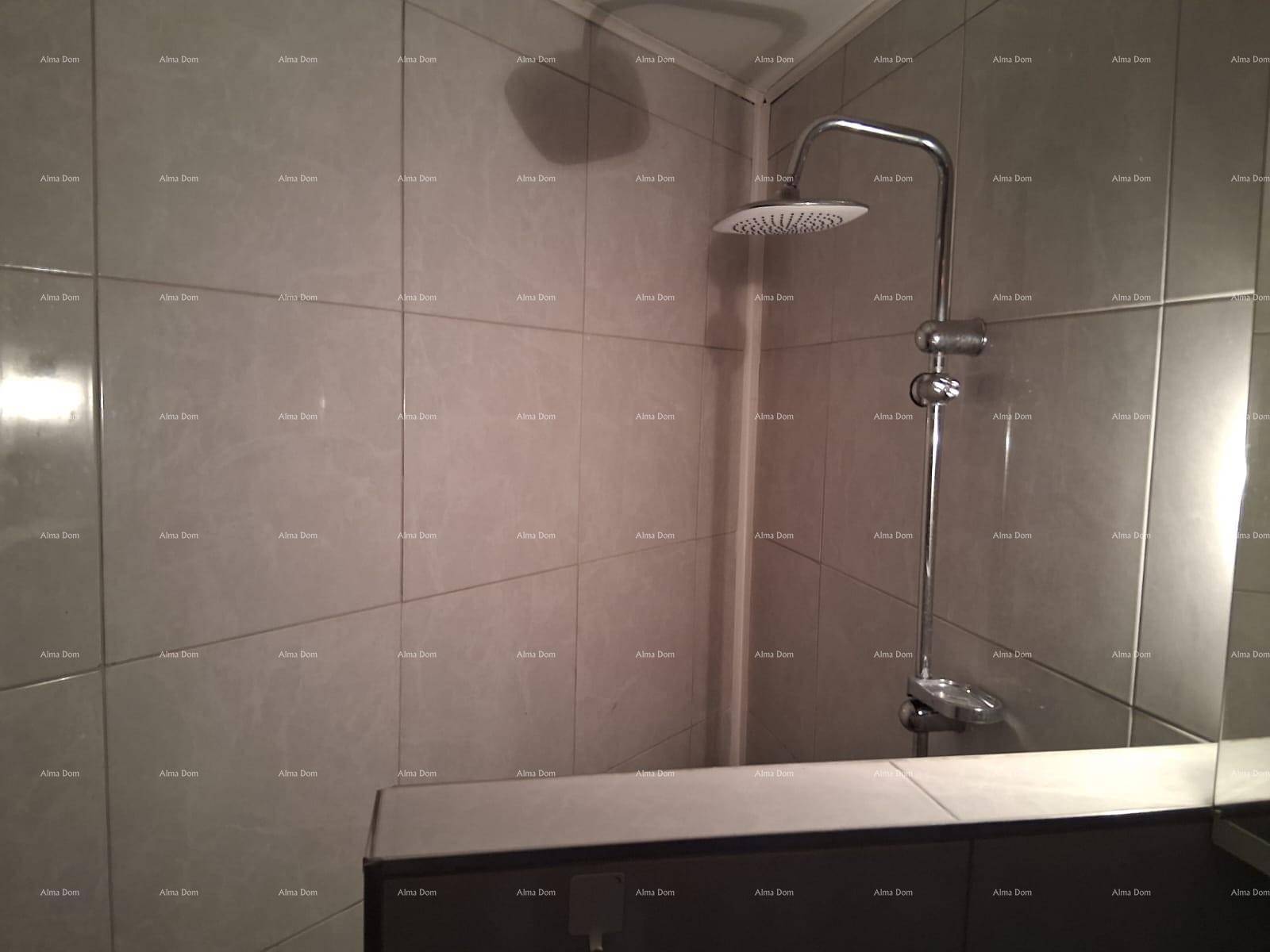 Duschbereich mit modernen grauen Fliesen und einer Regendusche.