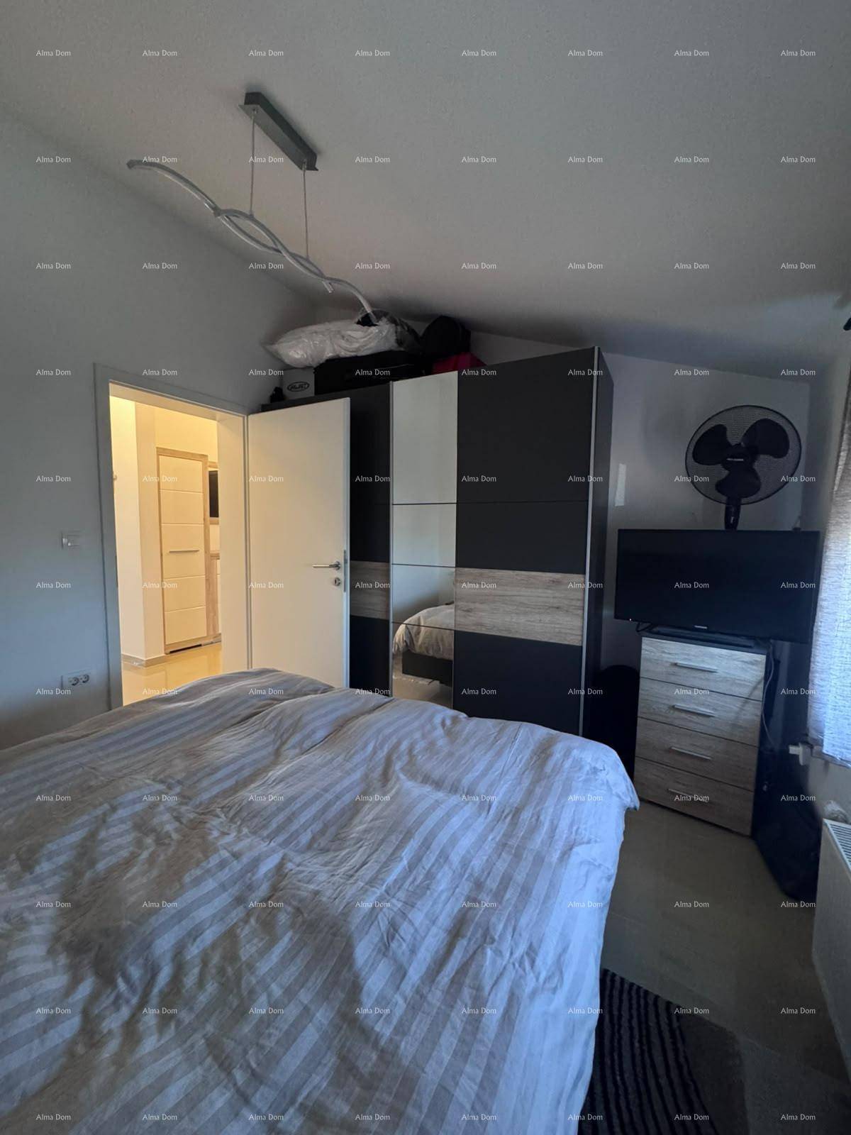 Schlafzimmer mit großem Bett und modernem Kleiderschrank, unter einer Dachschräge gelegen.