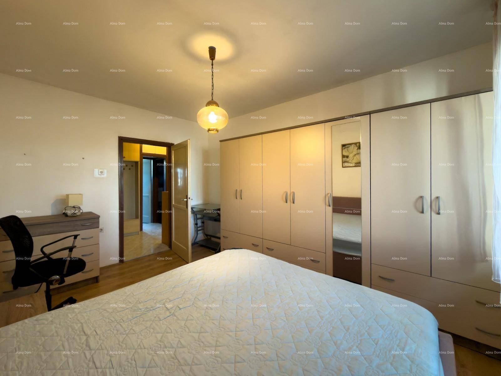 Schlafzimmer mit Kleiderschrank, Schreibtisch und Zugang zu einem weiteren Raum.
