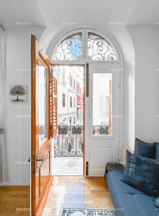 Französischer Balkon mit schmiedeeisernem Geländer und Blick auf die charmante Straße.