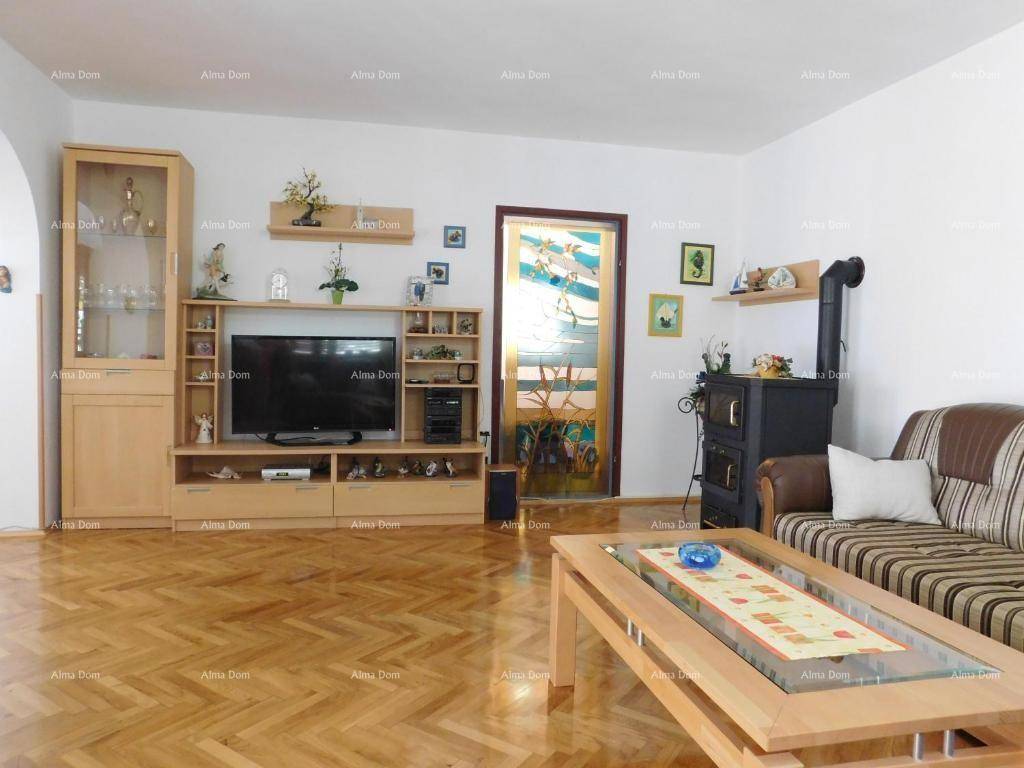 Geräumiges Wohnzimmer mit Holzparkett, Kaminofen und großer Medieneinheit.