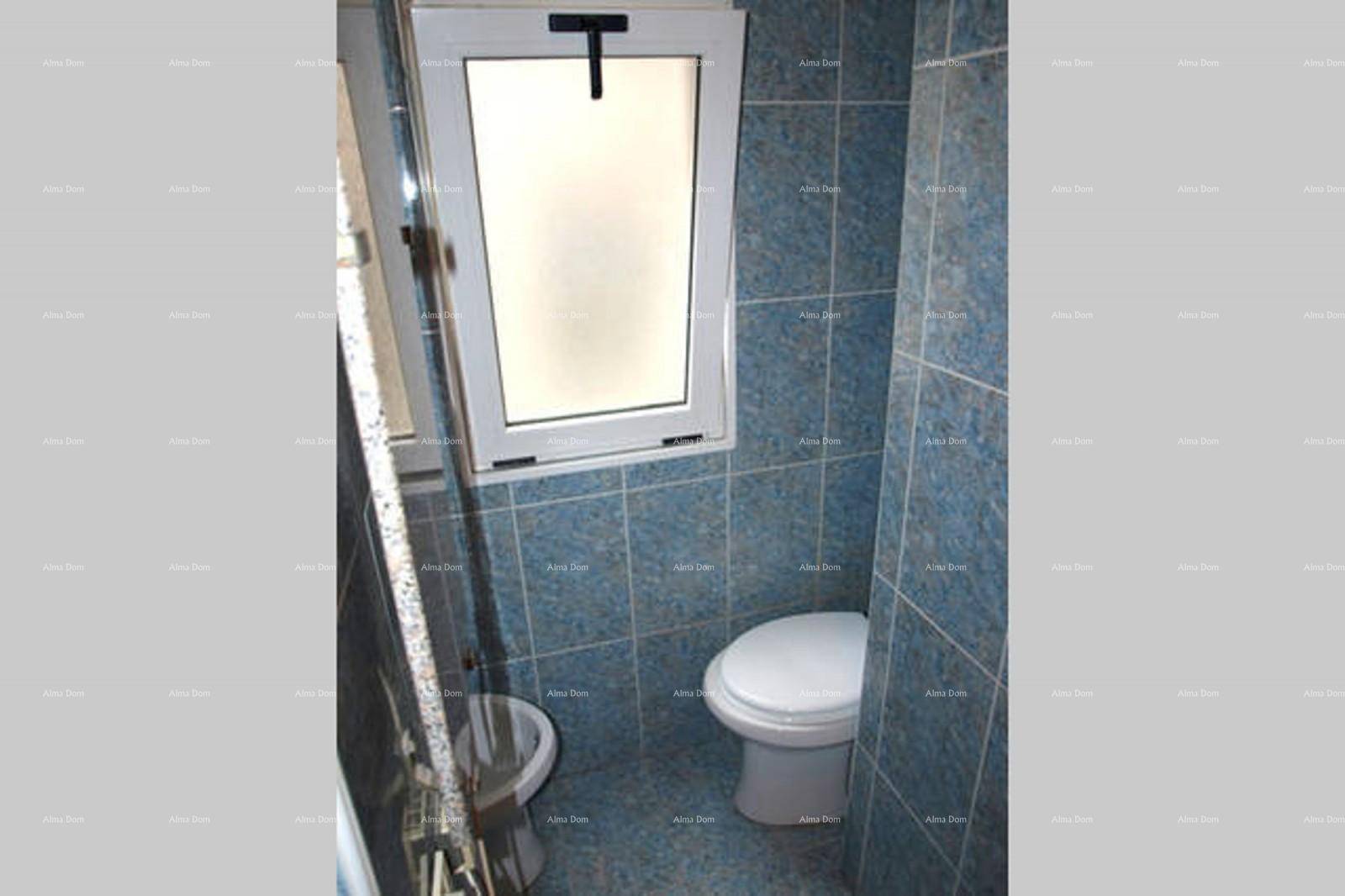 WC-Bereich im Badezimmer mit Bidet und Fenster für natürliche Belüftung.