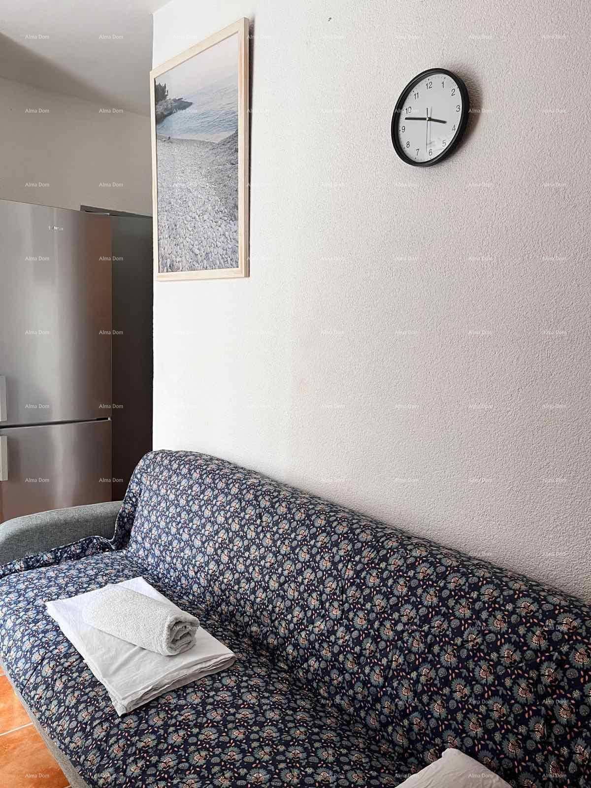 Schlafsofa mit frischen Handtüchern und einem Kühlschrank im Hintergrund des Wohnbereichs.