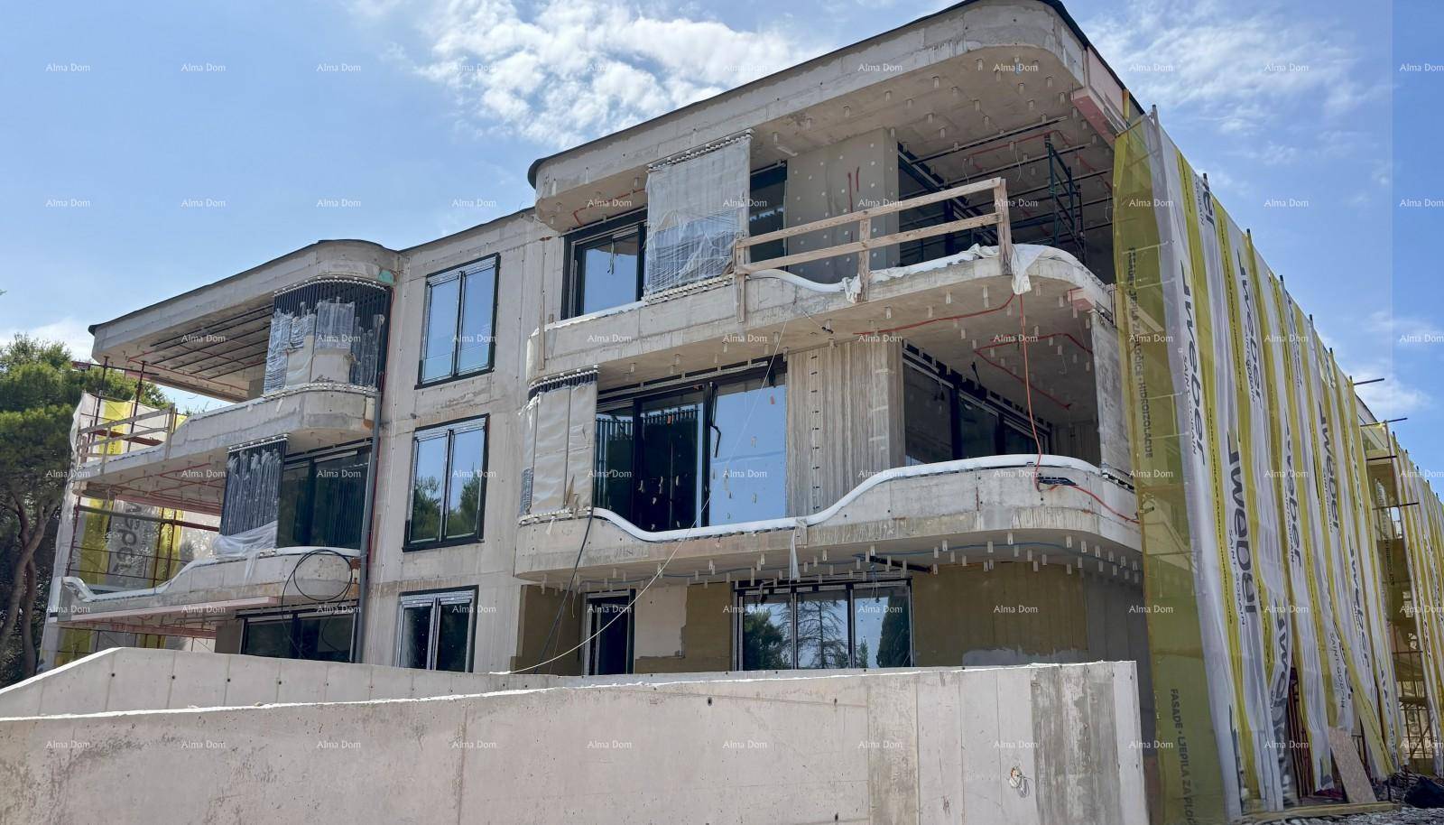 Neubau im Rohbau mit bereits installierten Fenstern und vorbereiteter Fassadendämmung.