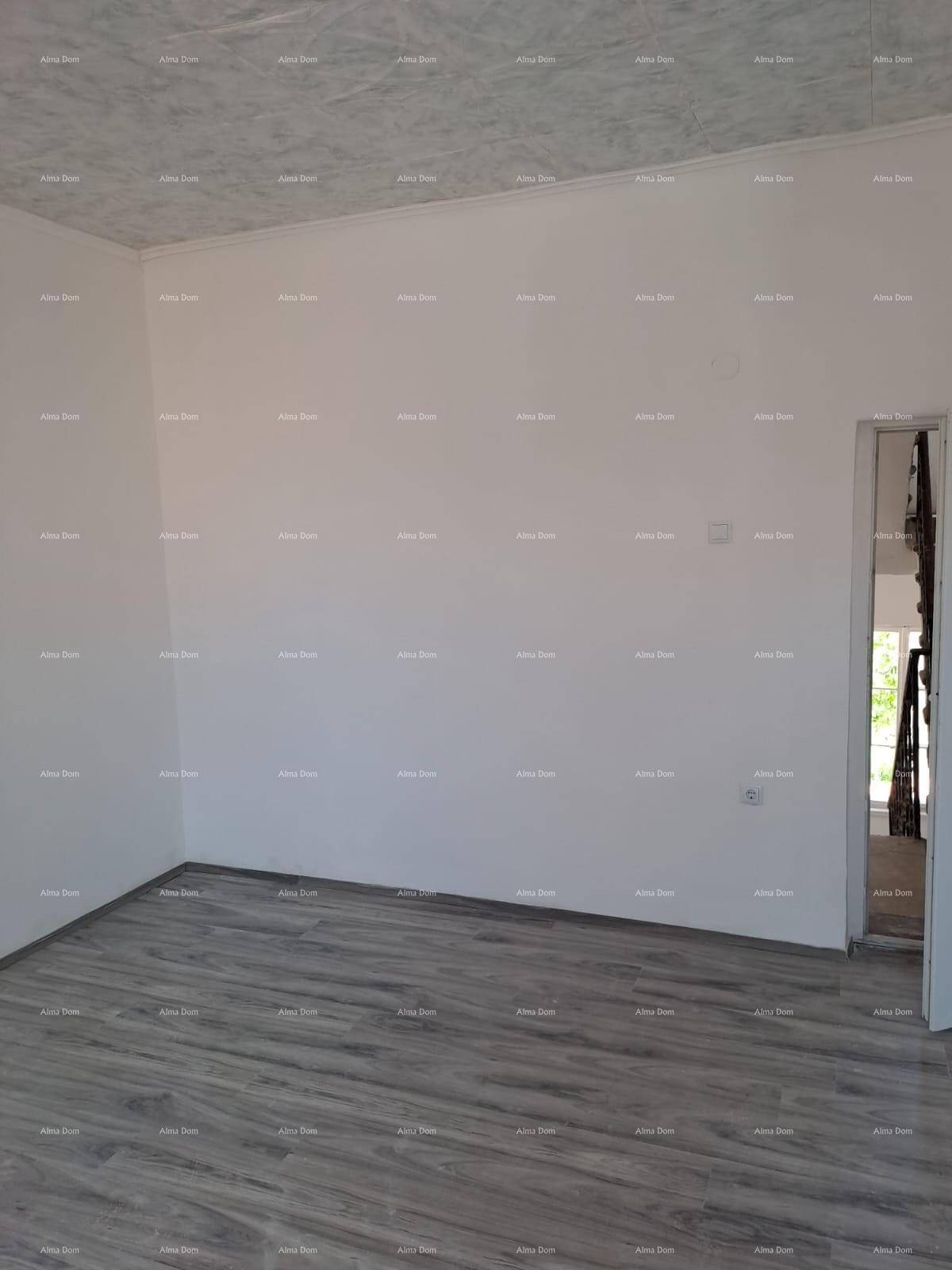 Leerer Raum mit Laminatboden und weiß gestrichenen Wänden, ideal für individuelle Gestaltung.