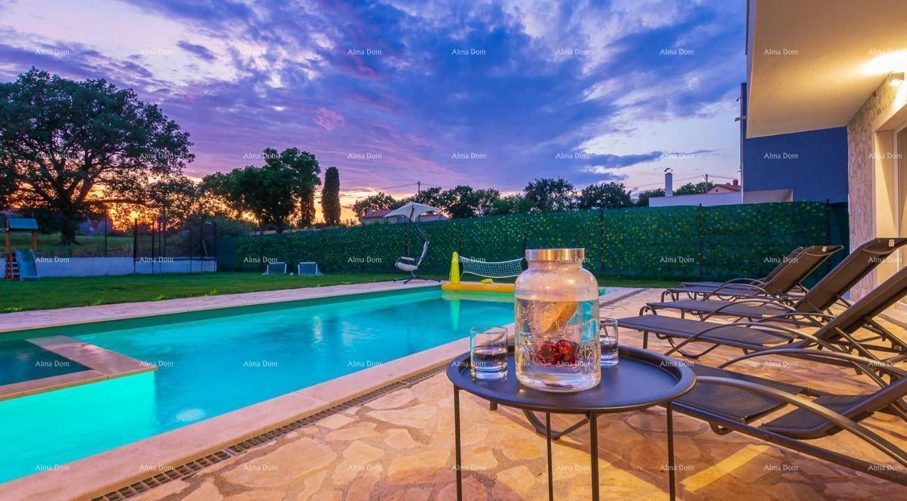 Abendstimmung am Pool mit beleuchtetem Wasser, Sonnenliegen und einem Getränketisch im Garten.