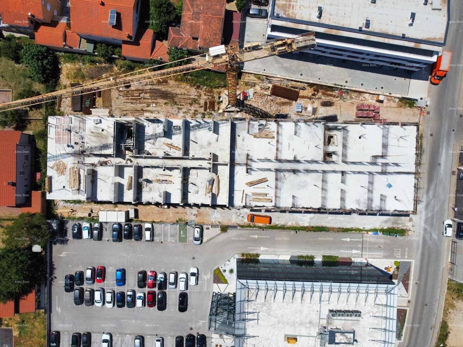Draufsicht auf eine große Baustelle mit Kran und Rohbau eines Gebäudes.