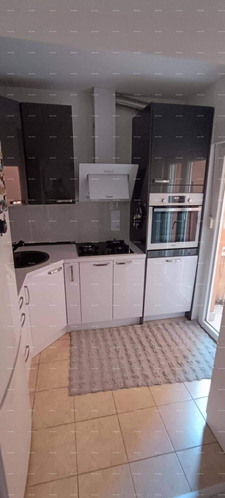 Moderne Küche mit weißen und grauen Schränken, integrierten Geräten und Fliesenboden.