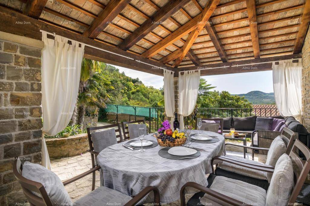 Überdachte Terrasse mit Esstisch, Lounge-Möbeln und weitem Blick ins Grüne.