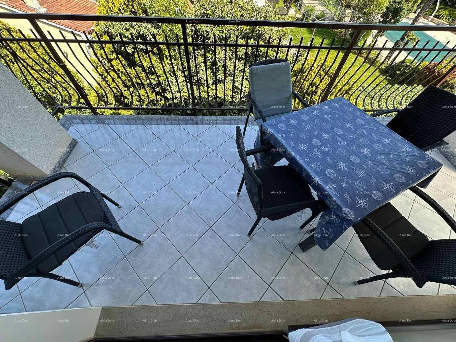 Detailansicht des Balkons mit Fliesenboden und schmiedeeisernem Geländer, umgeben von Grün.