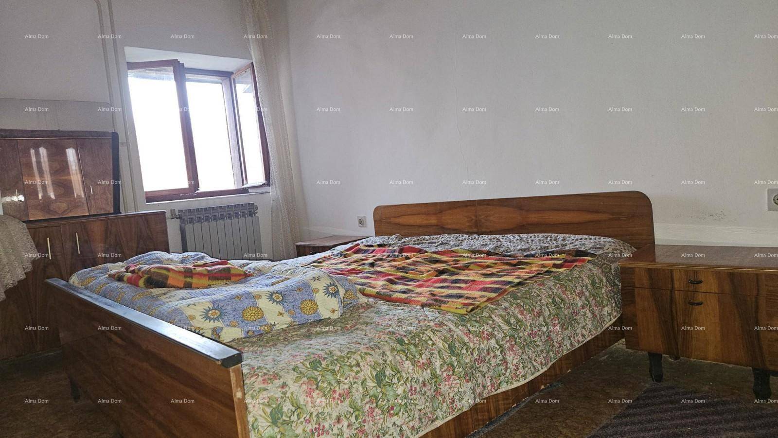 Schlafzimmer mit einem Doppelbett aus Holz, Nachttischen und einem Fenster für frische Luft.
