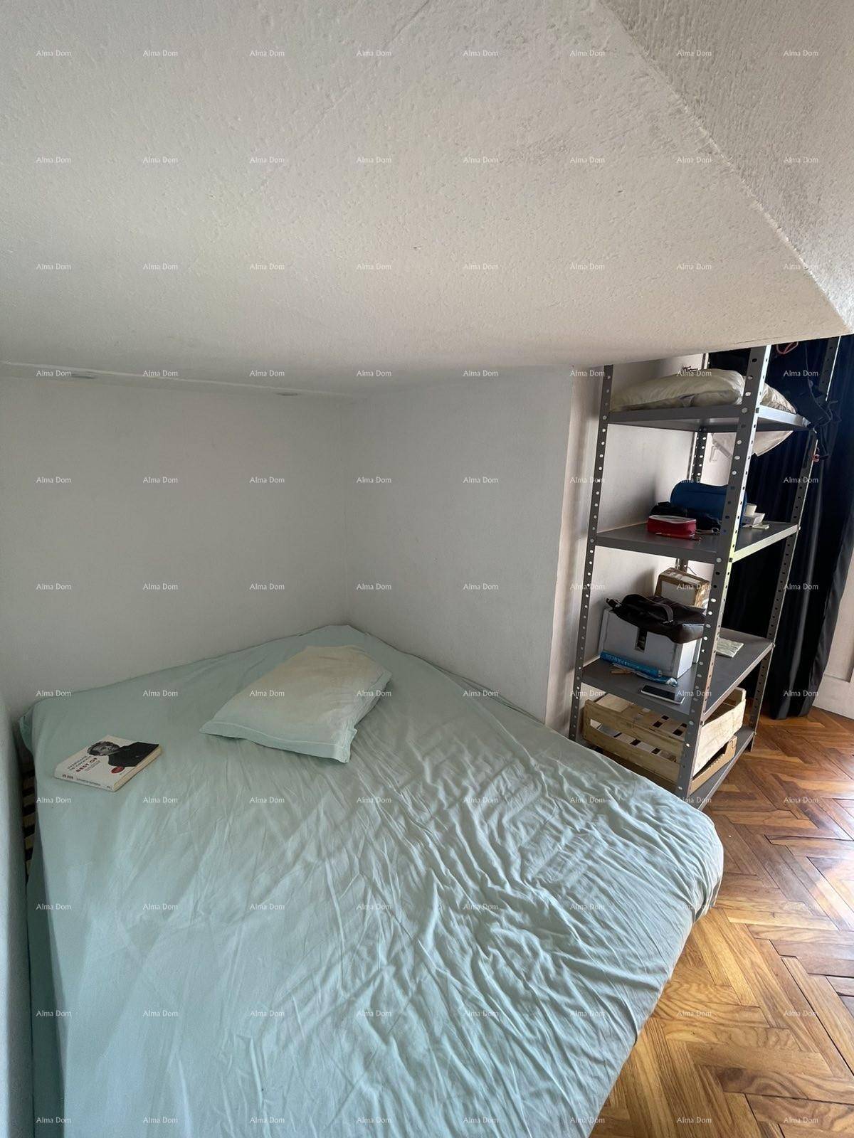 Schlafbereich mit Holzboden und einfacher Einrichtung, unter einer niedrigen Decke gelegen.